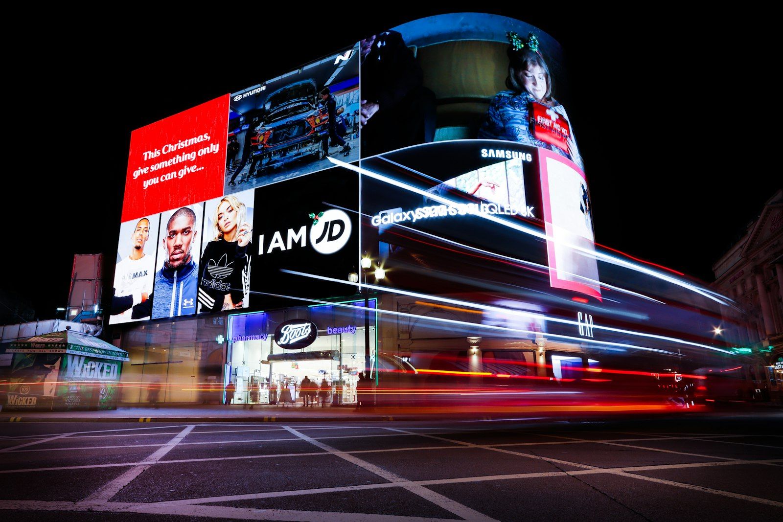Digital billboards lighting up a city street at night