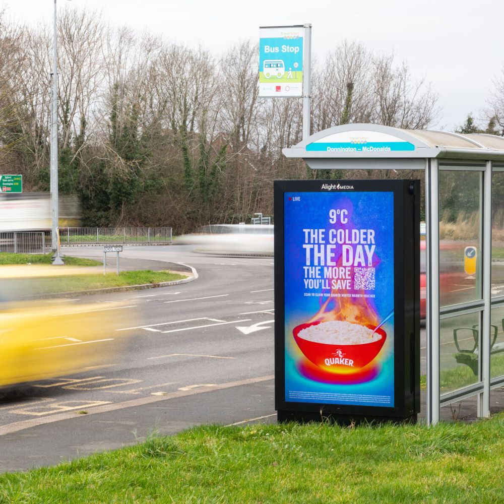 A digital bus shelter screen beside a road in Telford