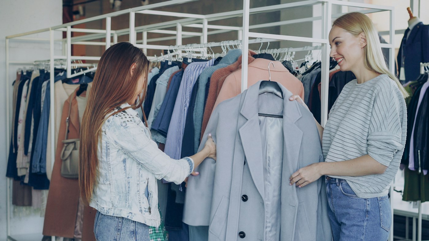 Two shoppers browsing clothing rails in a boutique