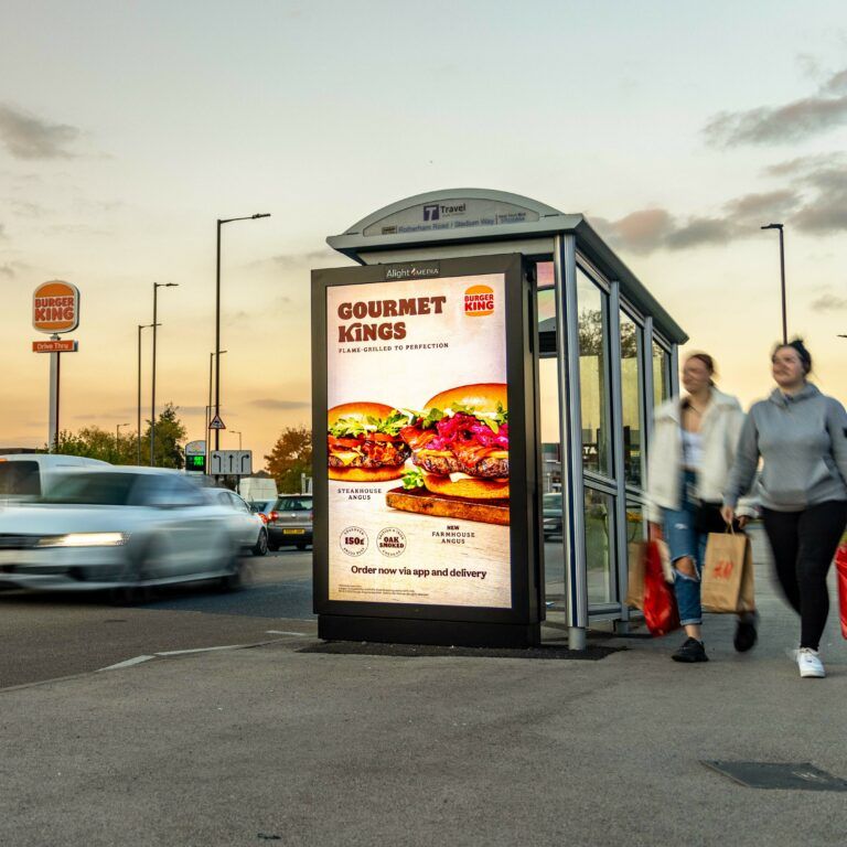 A digital bus shelter screen on a high street