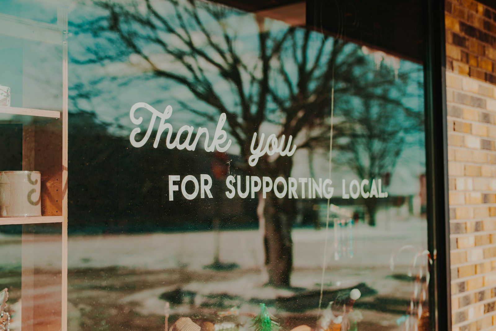 A shop window sign reading Thank you for supporting local